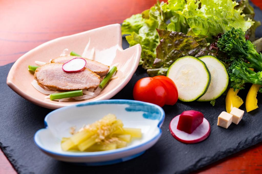 une table avec une assiette de nourriture et une salade dans l'établissement Hozanso Beppu, à Beppu 86 autres photos