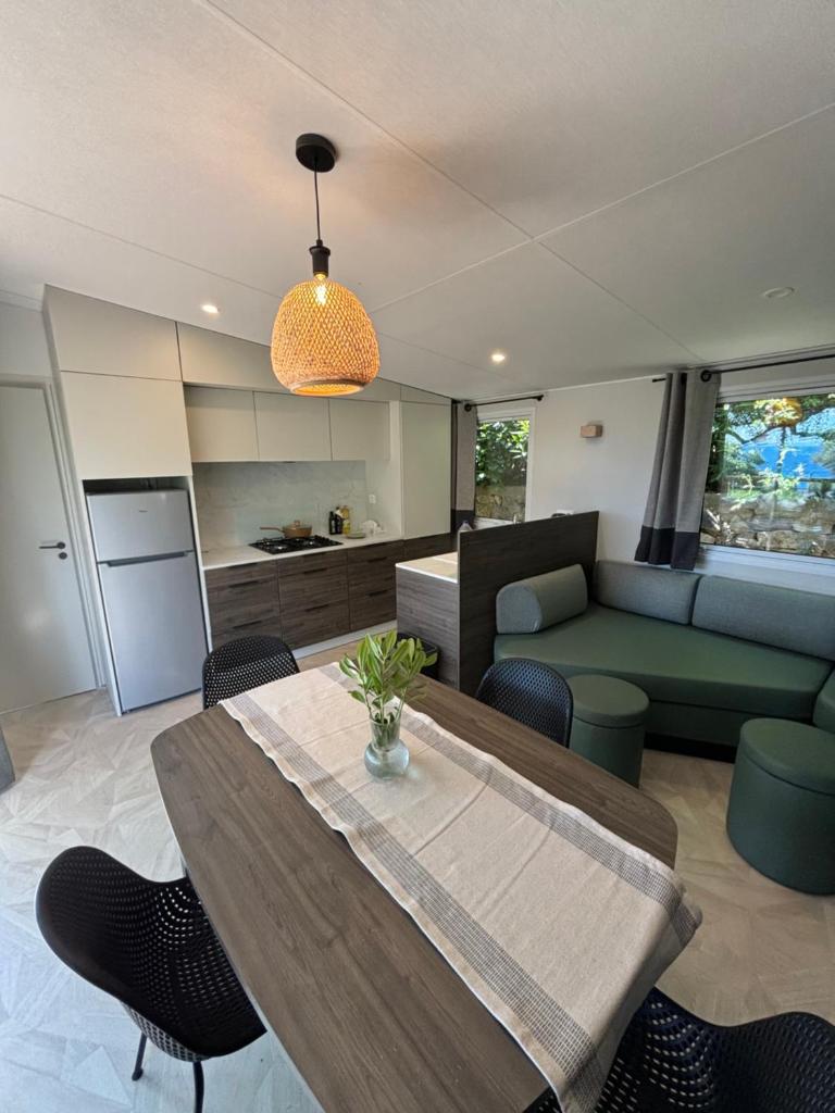 un salon avec une table et un canapé dans l'établissement Bungalow vue mer, jacuzzi, terrase, jardin, à Saint-Raphaël