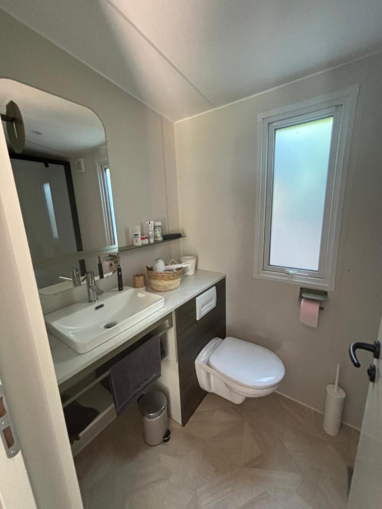 une salle de bain avec un lavabo et des toilettes et une fenêtre dans l'établissement Bungalow vue mer, jacuzzi, terrase, jardin, à Saint-Raphaël 37 autres photos