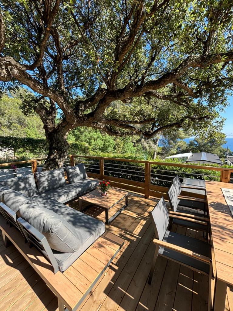 une terrasse avec des chaises longues et un arbre dans l'établissement Bungalow vue mer, jacuzzi, terrase, jardin, à Saint-Raphaël