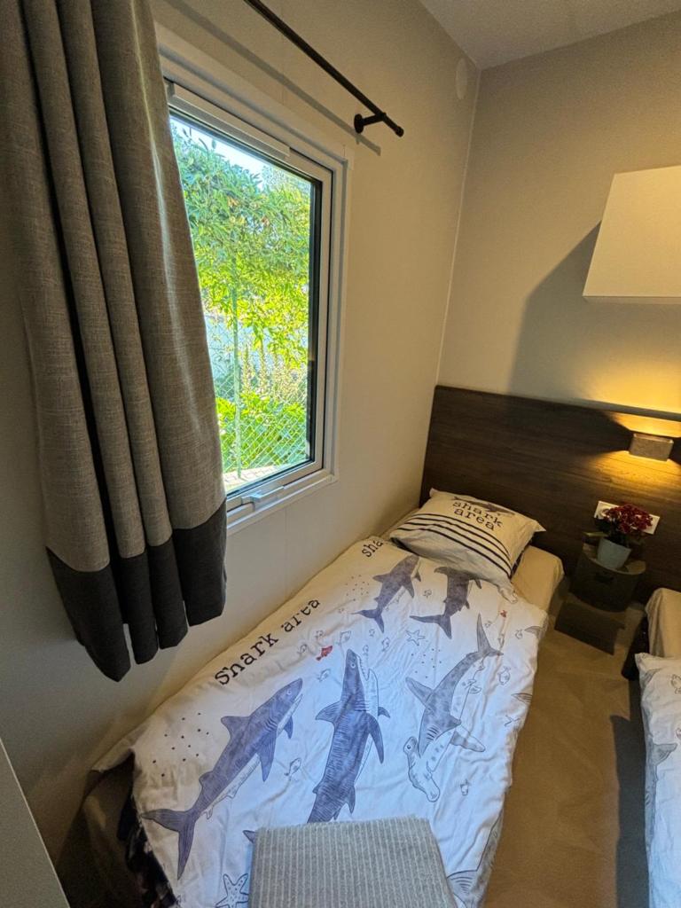 une chambre avec un lit et une fenêtre dans l'établissement Bungalow vue mer, jacuzzi, terrase, jardin, à Saint-Raphaël
