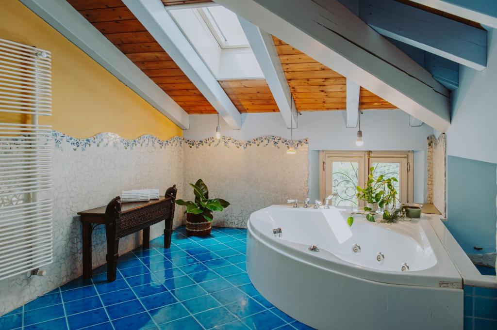 La grande salle de bains est pourvue d'une baignoire et d'une table. dans l'établissement Villa Frida, à Salò