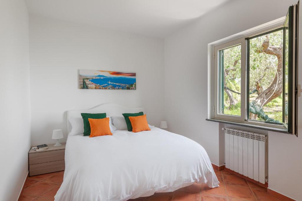 une chambre avec un lit blanc et une fenêtre dans l'établissement Villa Saretta Amalfi Views Pool & Guest Services by Feeling Italy, à Massa Lubrense