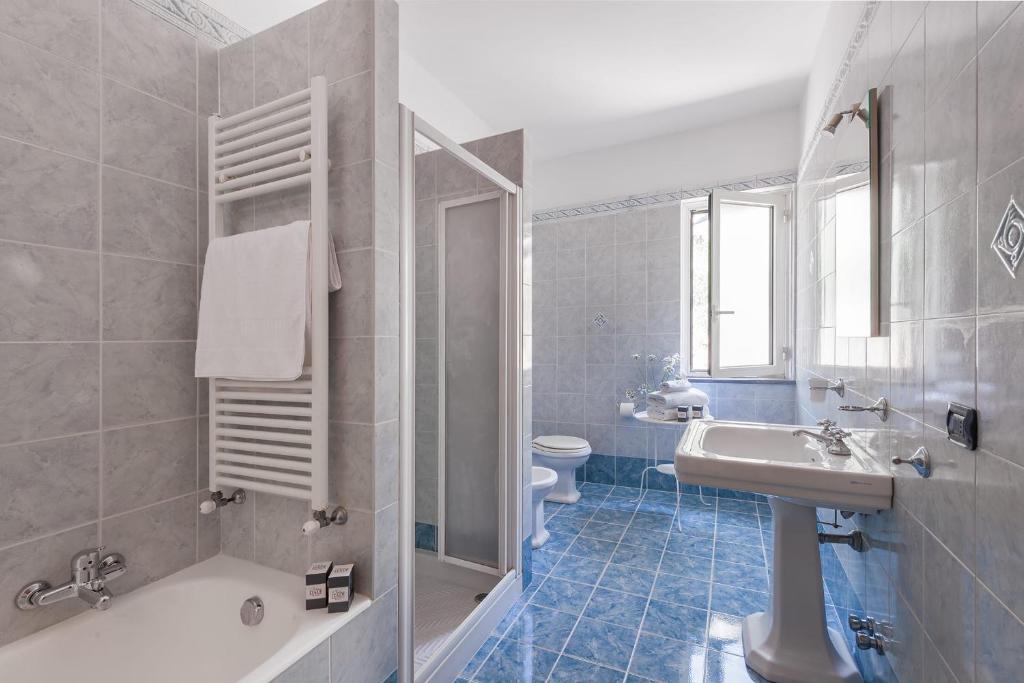 une salle de bain avec un lavabo, une baignoire et des toilettes dans l'établissement Villa Saretta Amalfi Views Pool & Guest Services by Feeling Italy, à Massa Lubrense