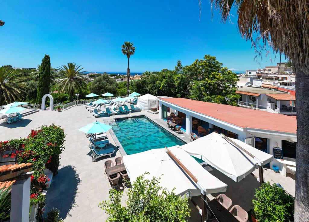 - une piscine avec des chaises et des parasols à côté d'un bâtiment dans l'établissement Av Club Terme Colella, à Ischia