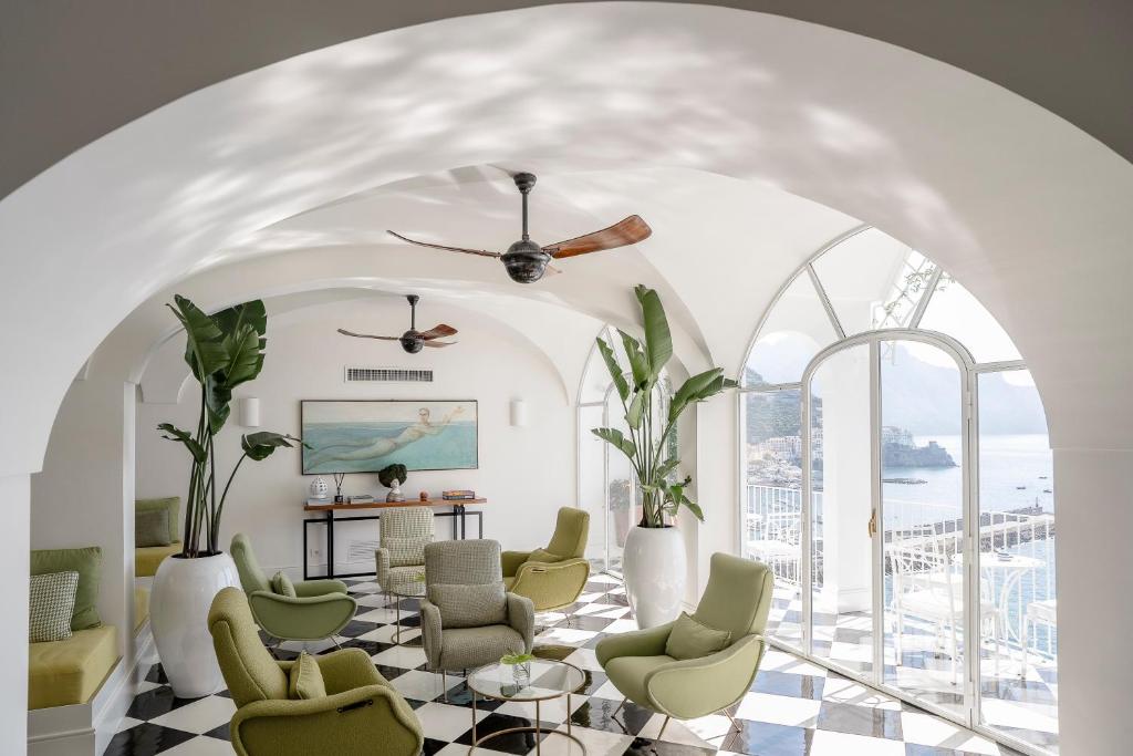 - un salon avec des chaises et un ventilateur de plafond dans l'établissement Hotel Miramalfi, à Amalfi