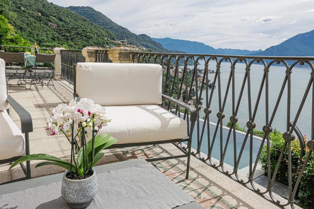 une chaise blanche assise sur un balcon donnant sur l'eau dans l'établissement La Wally - 4 Bedroom Villa with Pool & Lake View, à Bellano