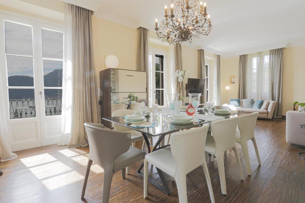 une salle à manger avec une table et des chaises blanches dans l'établissement La Wally - 4 Bedroom Villa with Pool & Lake View, à Bellano
