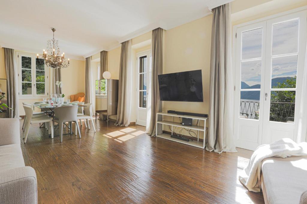 un salon avec une télévision et une salle à manger dans l'établissement La Wally - 4 Bedroom Villa with Pool & Lake View, à Bellano 43 autres photos