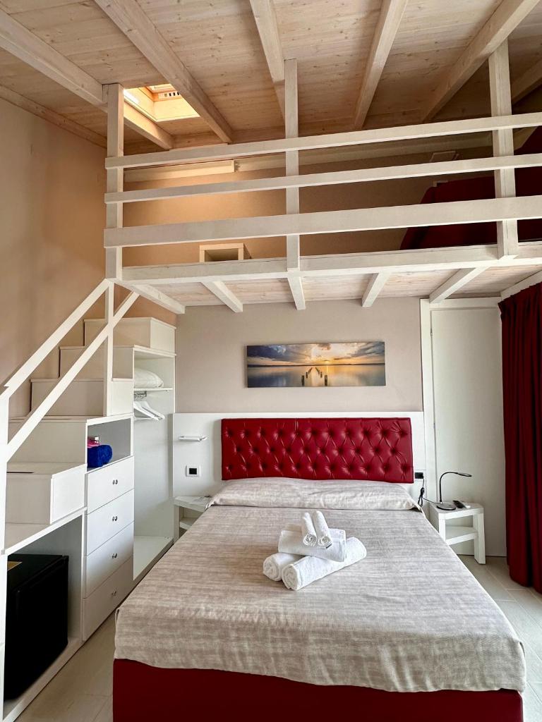 une chambre avec un grand lit avec une tête de lit rouge dans l'établissement Blue Inn Residence e B&B, à Lido delle Nazioni 19 autres photos