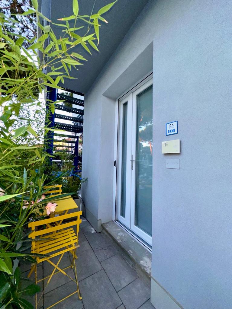 un banc jaune assis à côté d'un bâtiment avec une fenêtre dans l'établissement Blue Inn Residence e B&B, à Lido delle Nazioni