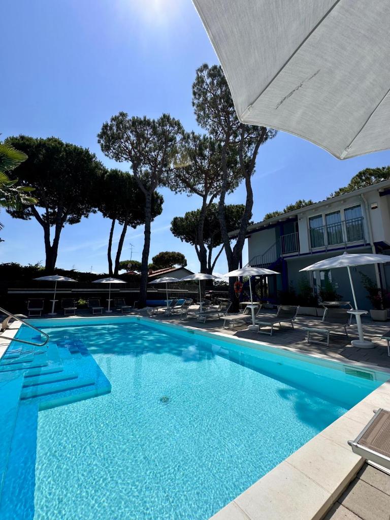 une grande piscine bleue avec chaises et parasols dans l'établissement Blue Inn Residence e B&B, à Lido delle Nazioni