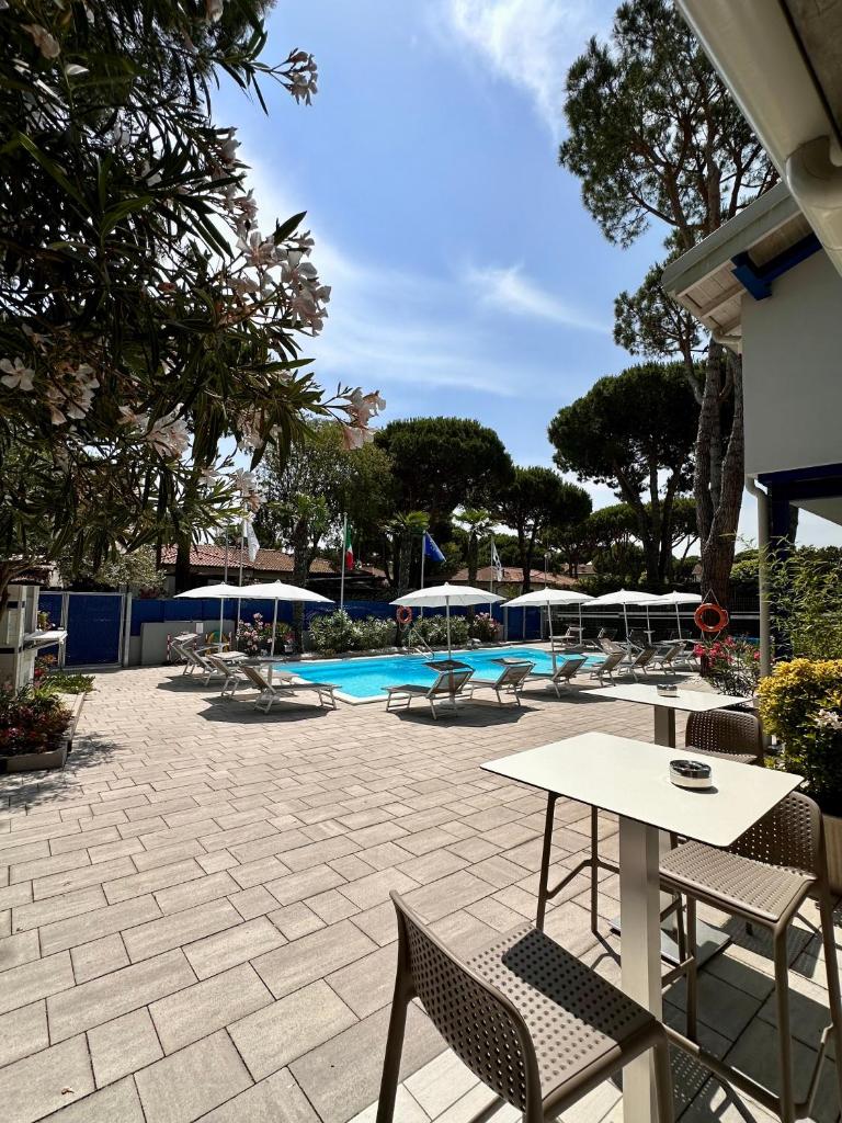 un patio avec une table et des chaises et une piscine dans l'établissement Blue Inn Residence e B&B, à Lido delle Nazioni