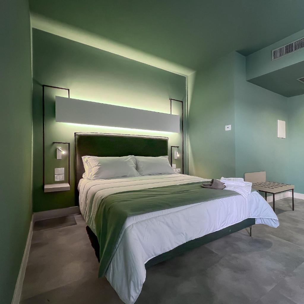 une chambre avec un grand lit avec un mur végétal dans l'établissement Maiorano Boutique Hotel, à Manfredonia