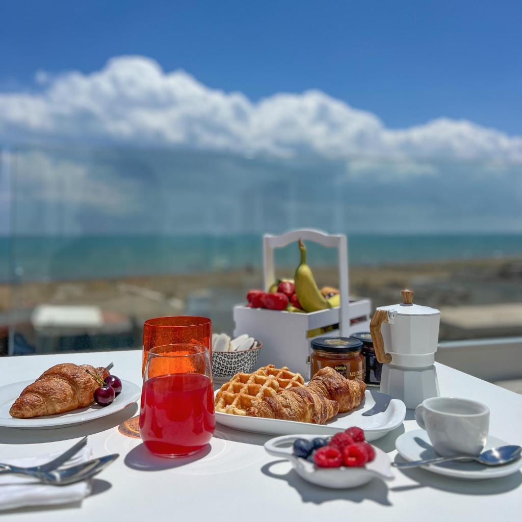 - une table avec un petit-déjeuner composé de viennoiseries et de fruits dans l'établissement Maiorano Boutique Hotel, à Manfredonia