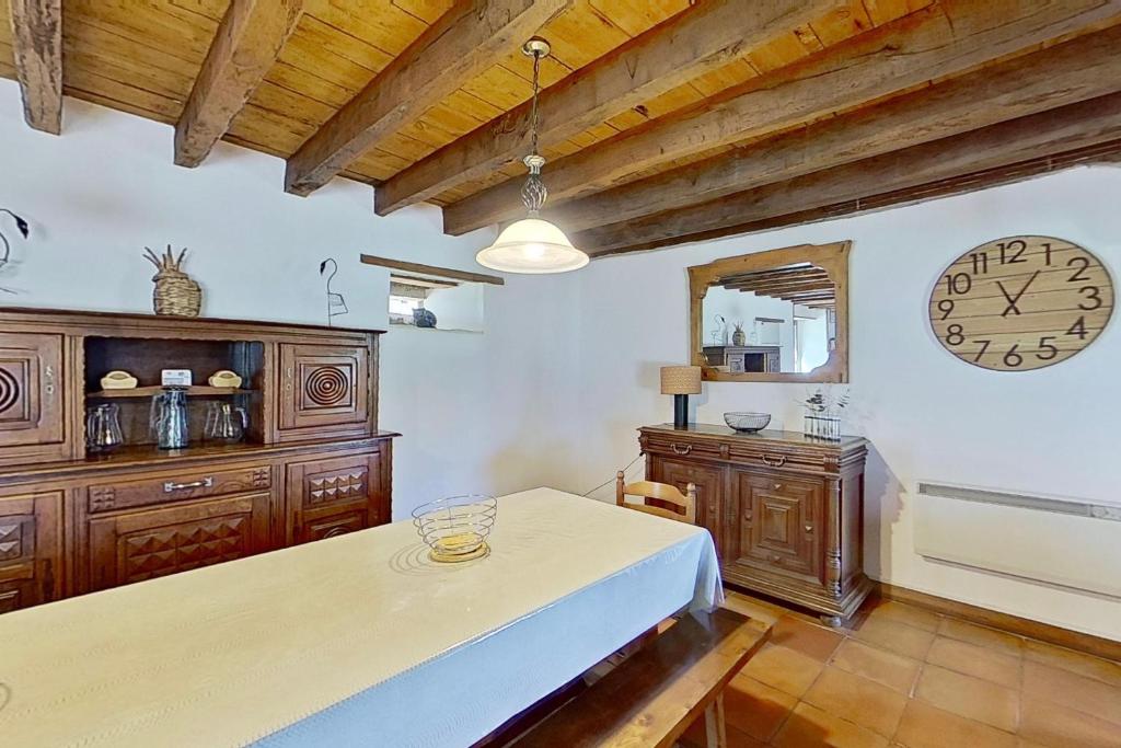 une pièce avec une table et une horloge au mur dans l'établissement Domaine de Montanty, à Gramat