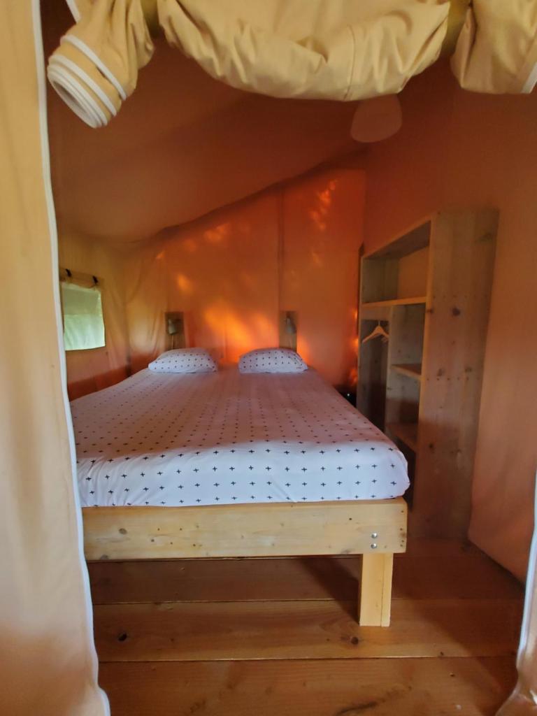 une chambre avec un lit dans une pièce dans l'établissement Tente Belle vue, à Rouffignac-Saint-Cernin-de-Reilhac