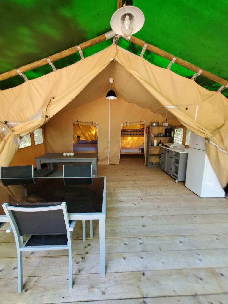une tente avec une table et des chaises à l'intérieur dans l'établissement Tente des bois, à Rouffignac-Saint-Cernin-de-Reilhac 35 autres photos
