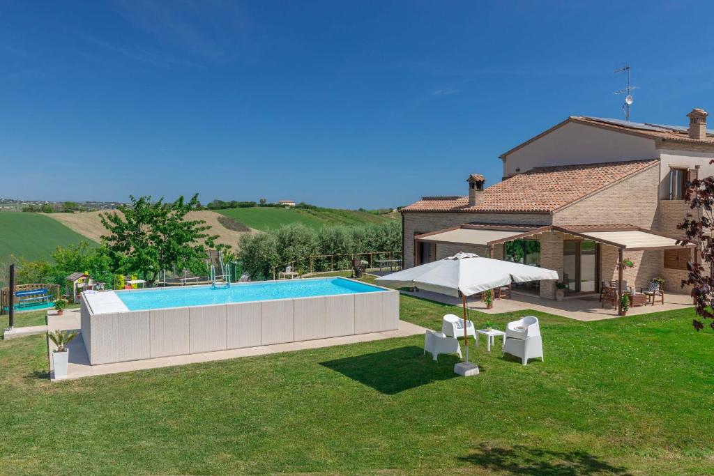 une maison avec une piscine dans une cour dans l'établissement Italian Experience-Villa Clair, à Fermo