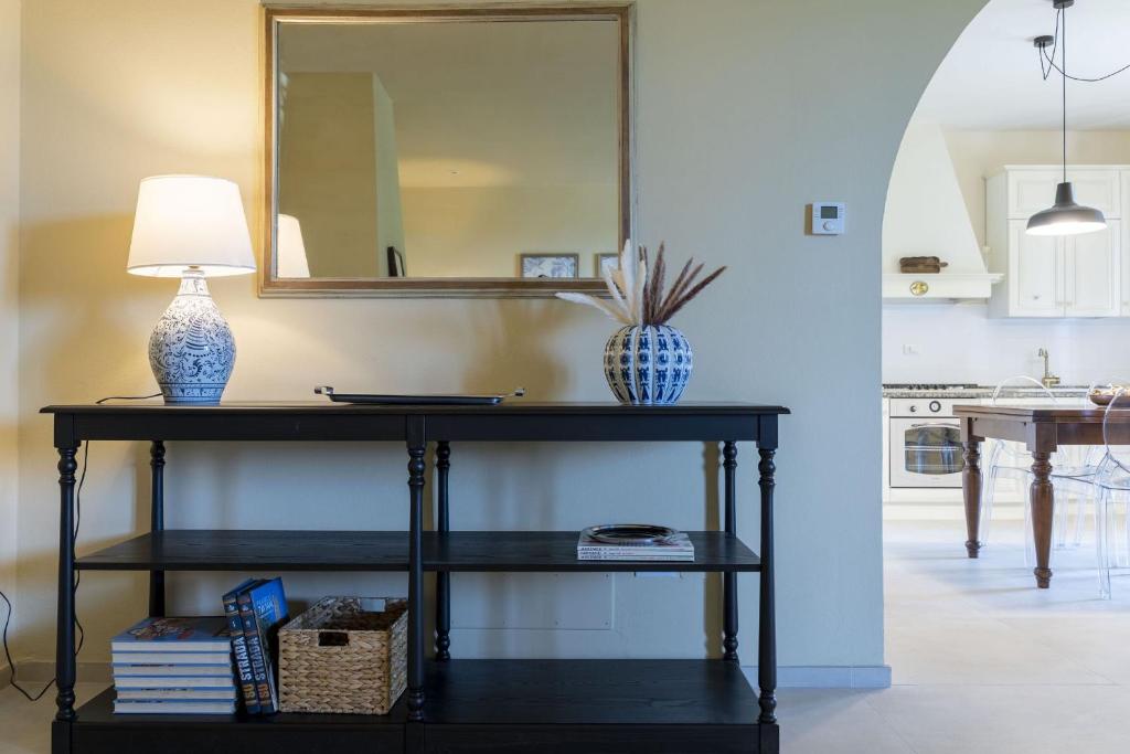 une console noire avec une lampe et un miroir dans l'établissement Italian Experience-Villa Zara, à San Miniato