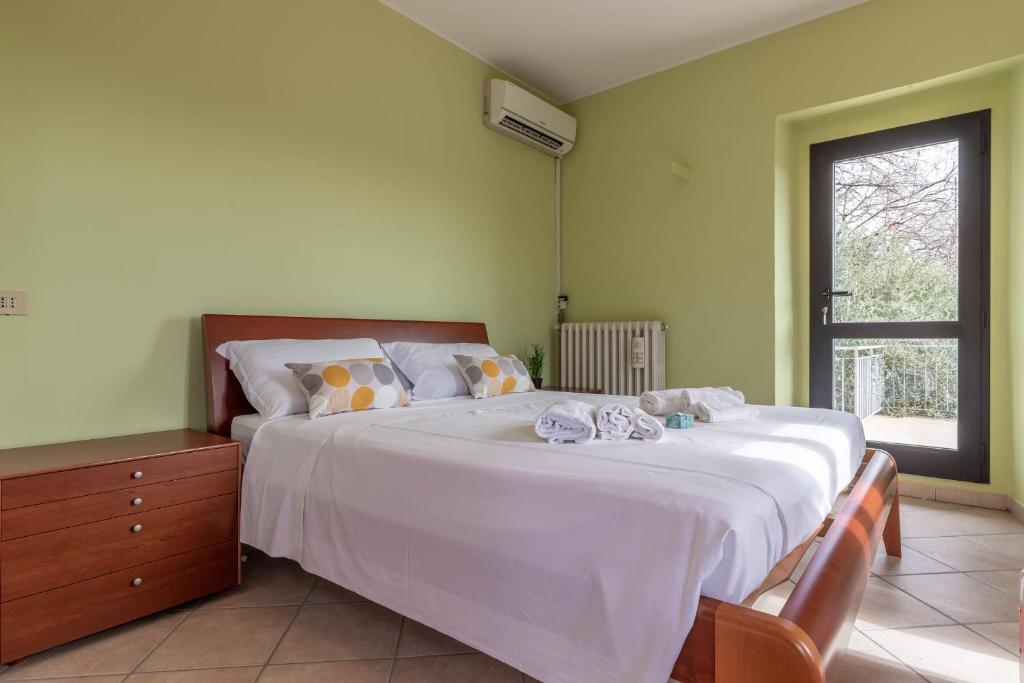 un grand lit blanc dans une chambre avec une fenêtre dans l'établissement Italian Experience- Villa La Pagliarina, à Cartoceto