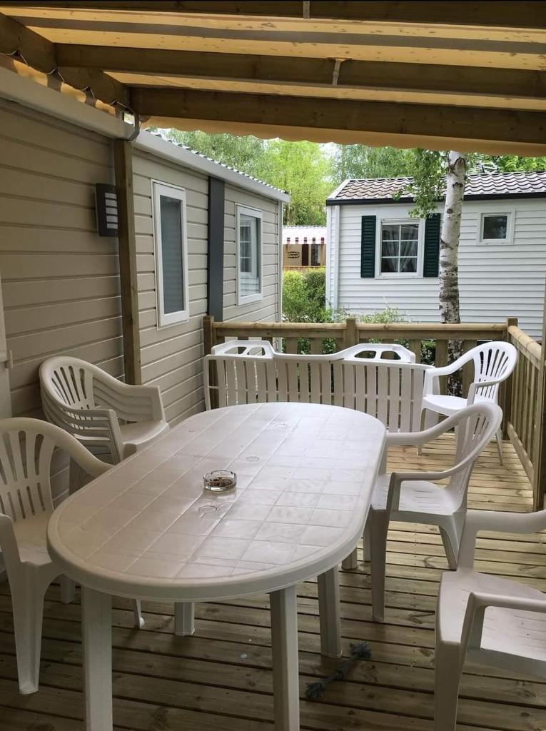 une table et des chaises blanches sur une terrasse dans l'établissement Mobil-home avec WIFI 6 à 8 couchages Domaine 4 étoiles au cœur des Châteaux de la Loire, à Onzain