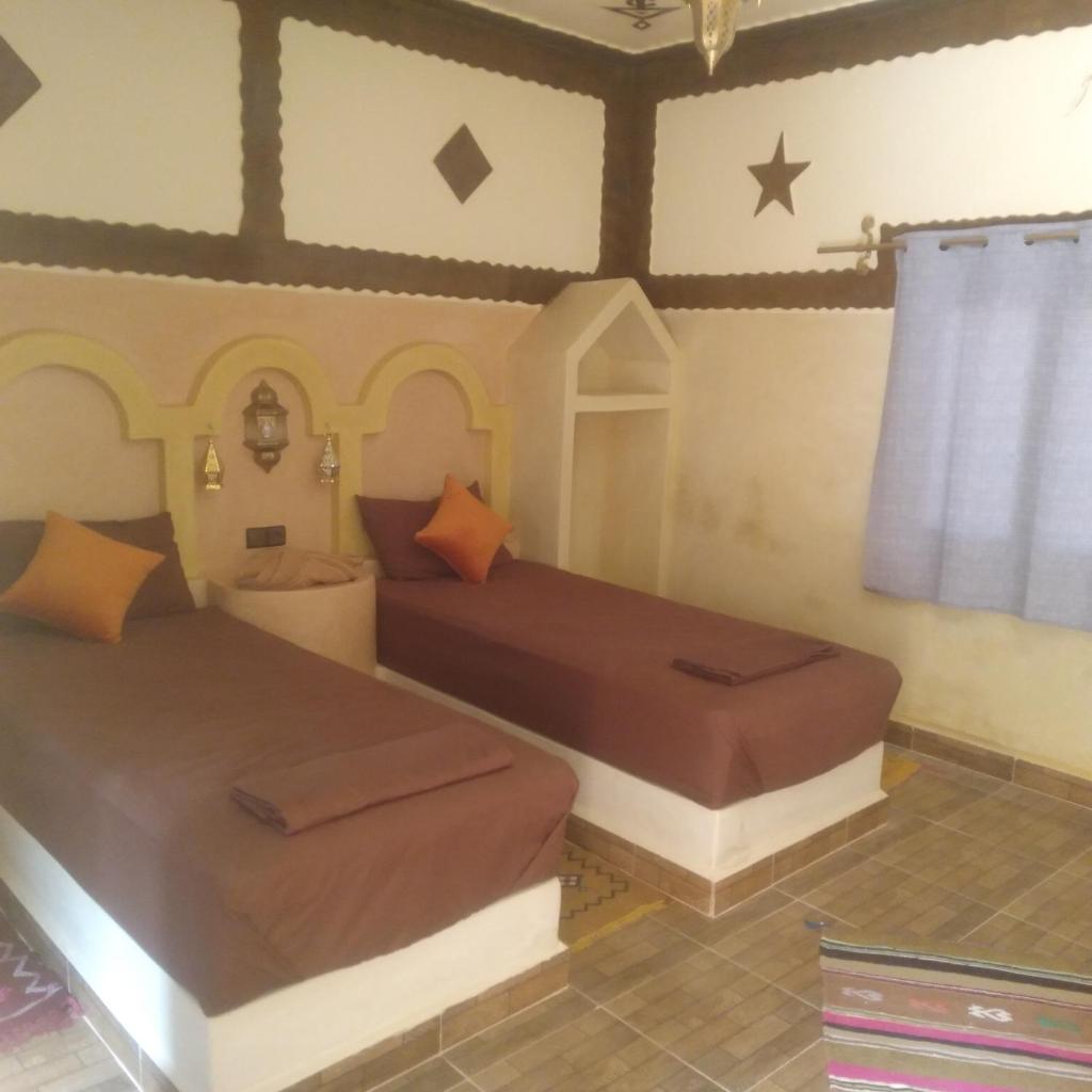 une chambre avec deux lits dans une pièce dans l'établissement Riad Berber Merzouga, à Merzouga