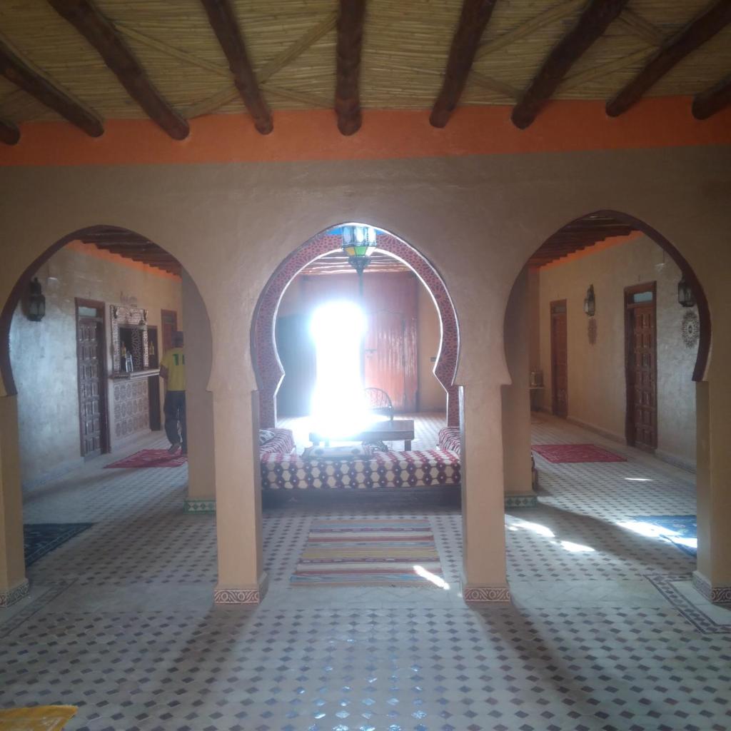 une pièce avec deux arches et une grande fenêtre dans l'établissement Riad Berber Merzouga, à Merzouga