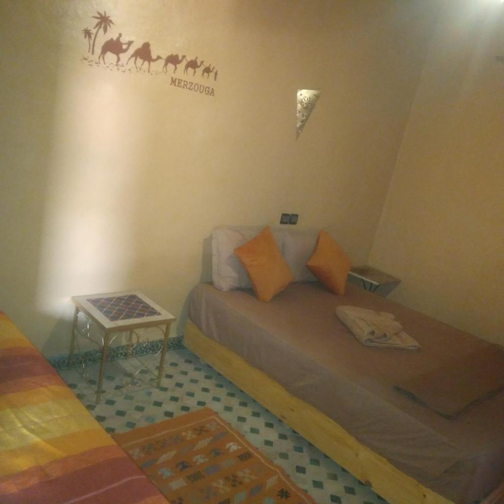 une petite chambre avec un lit et une table dans l'établissement Riad Berber Merzouga, à Merzouga