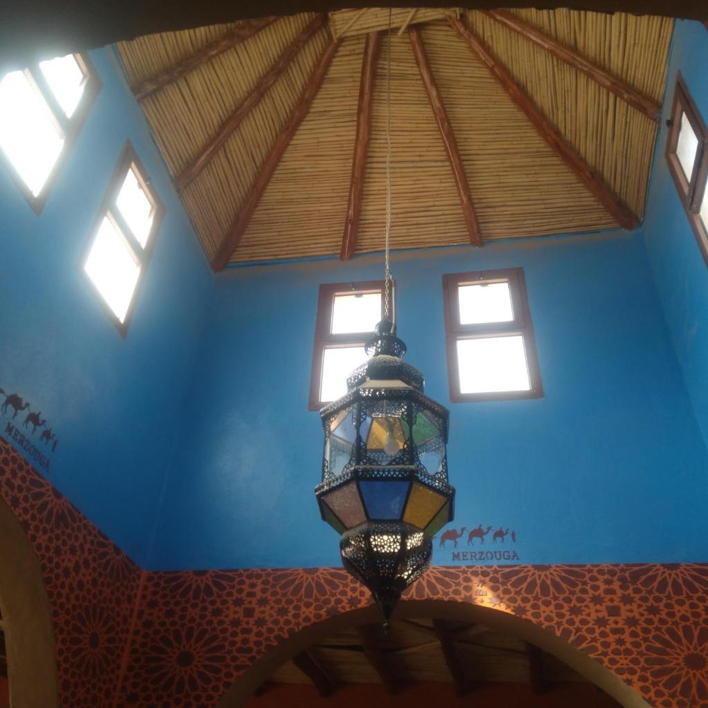 un lustre suspendu au plafond d'une pièce dans l'établissement Riad Berber Merzouga, à Merzouga