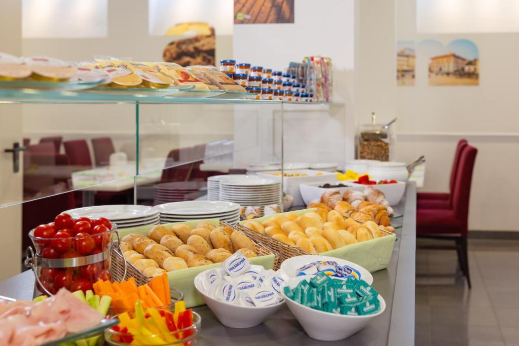 un buffet avec différents types de nourriture sur une table dans l'établissement Hotel Trieste Mare, à Lignano Sabbiadoro