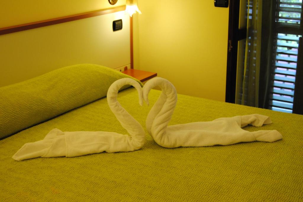 deux serviettes en forme de cygnes posées sur un lit dans l'établissement Residence Villa Il Glicine, à Taormine 19 autres photos