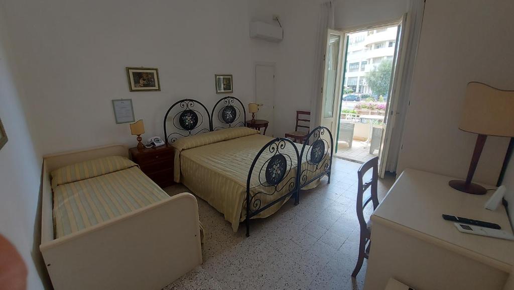 une chambre avec deux lits et une fenêtre dans l'établissement Albergo Regina, à Senigallia