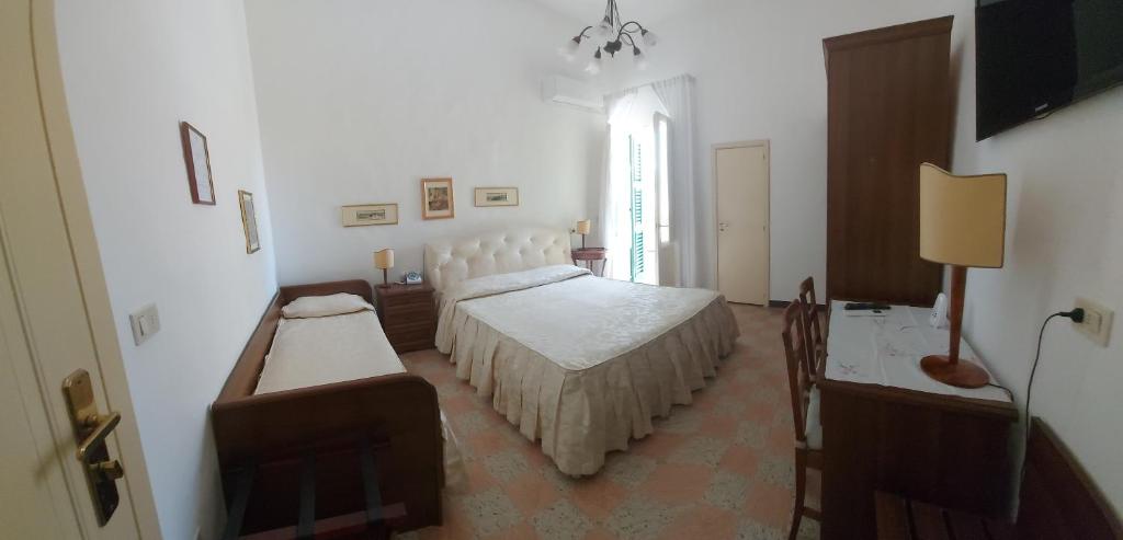 une chambre blanche avec deux lits et une fenêtre dans l'établissement Albergo Regina, à Senigallia