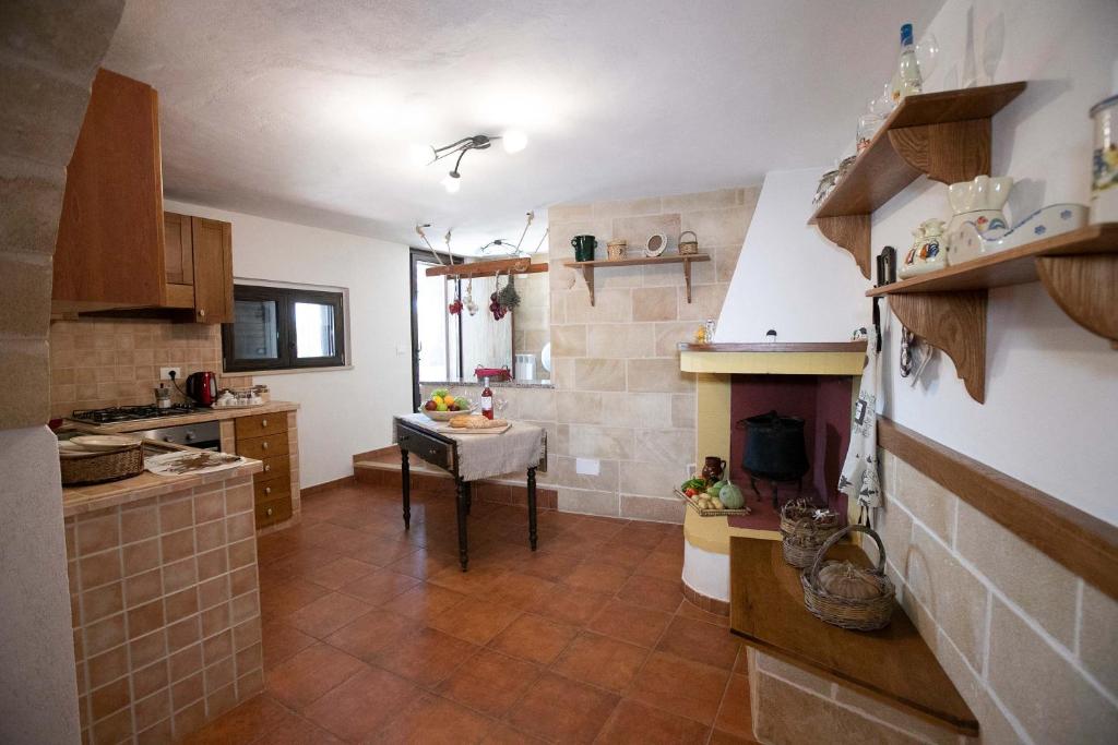 une cuisine avec un évier et une table à l'intérieur dans l'établissement Tenuta Arianna by Perle di Puglia, à Cisternino