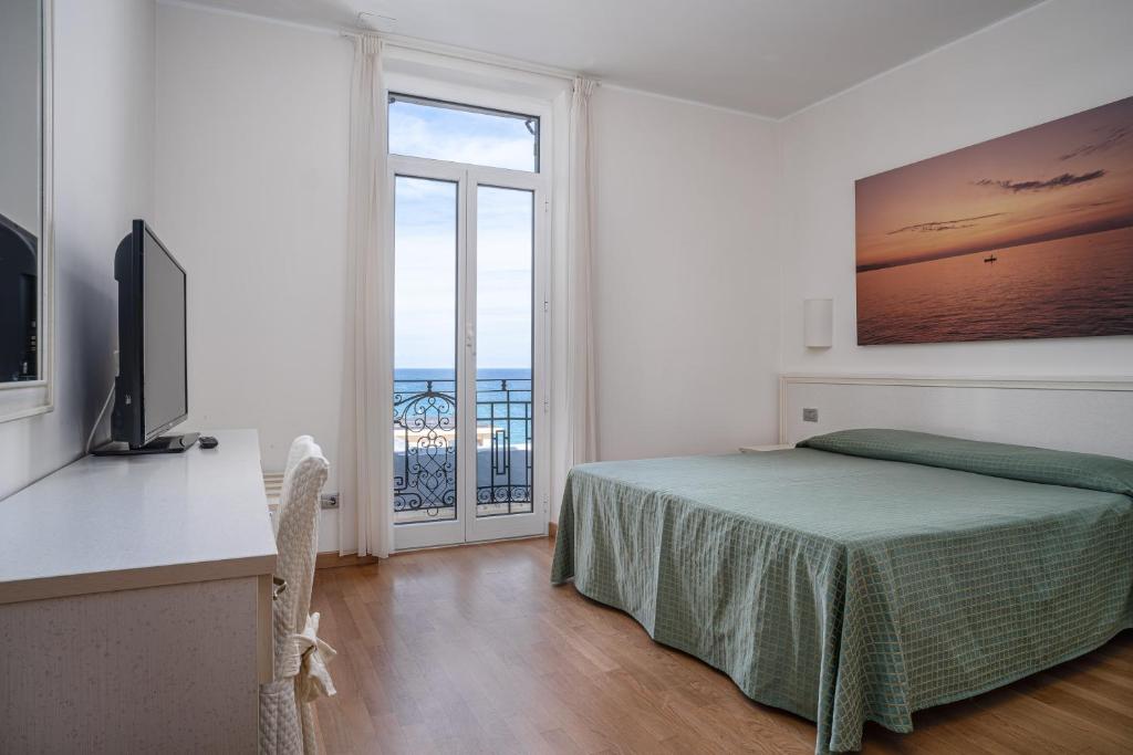 une chambre avec un lit et une vue sur l'océan dans l'établissement Lido Resort, à Finale Ligure