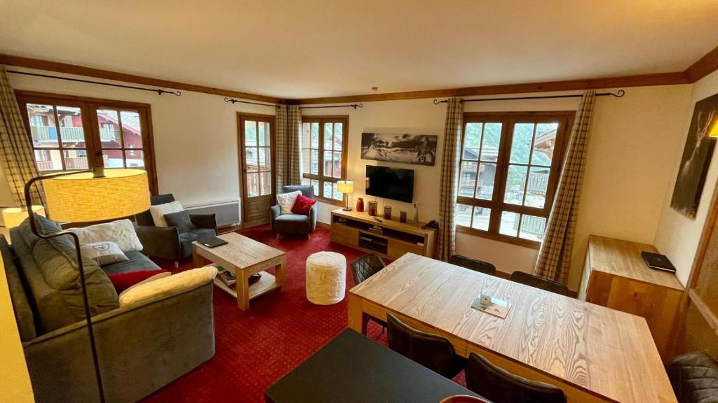 un salon avec un canapé et une table dans l'établissement Arc 1950 - Appt 2CH - 6 pers - Rés 5* luxe - Piscine, sauna, hamman, jacuzzi - Classé 5 cristaux Paradiski, à Arc 1950