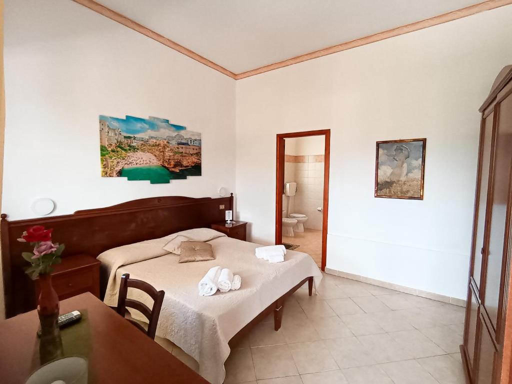 une chambre avec un lit, une table et un miroir dans l'établissement Hotel Grotticelli, à Scopello 48 autres photos