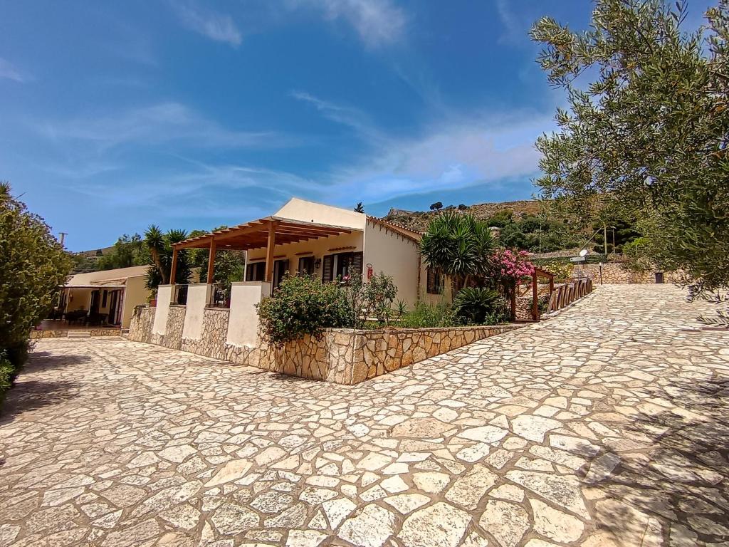 une maison avec une allée en pierre devant un bâtiment dans l'établissement Hotel Grotticelli, à Scopello