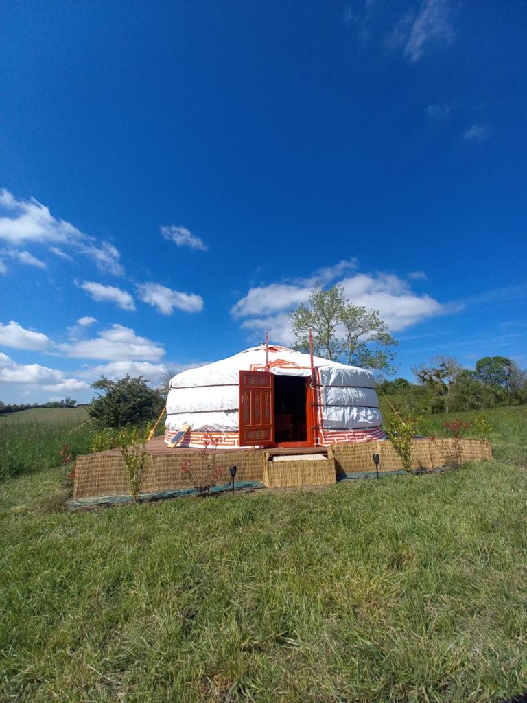 une grande tente en forme de dôme installée dans un champ dans l'établissement Yourte calvados, à Les Moutiers-en-Auge