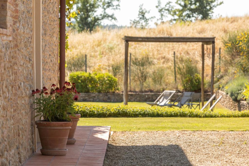 un patio avec un jardin et une cour avec balançoire dans l'établissement Luminoso Fienile vista vigne, à Castiglioni
