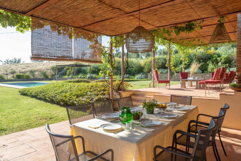 une table et des chaises sous un pavillon avec une table et des chaises dans l'établissement Luminoso Fienile vista vigne, à Castiglioni 33 autres photos