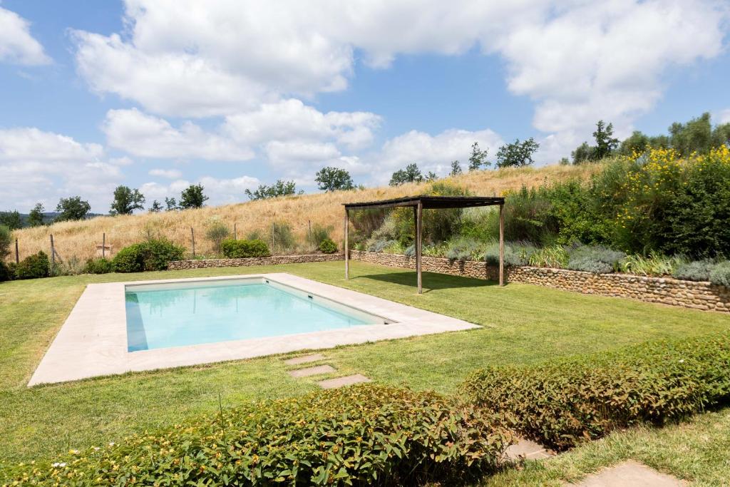 une piscine dans un jardin avec un kiosque dans l'établissement Luminoso Fienile vista vigne, à Castiglioni