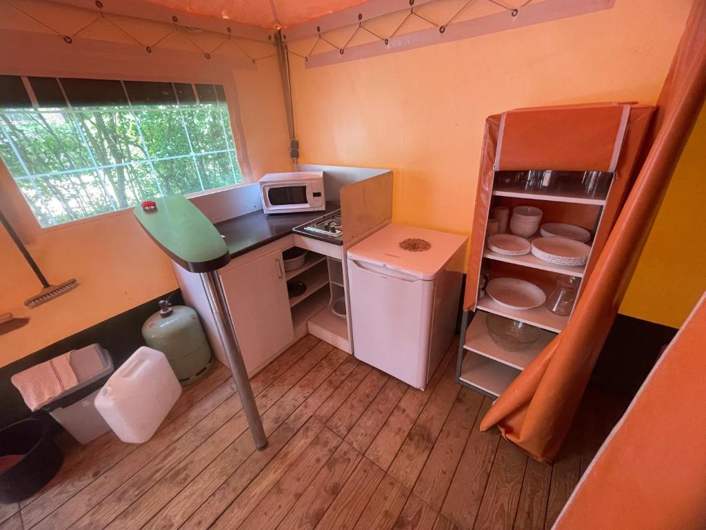 une petite cuisine avec un réfrigérateur et un micro-ondes dans l'établissement Camping Sainte Victoire, à Beaurecueil