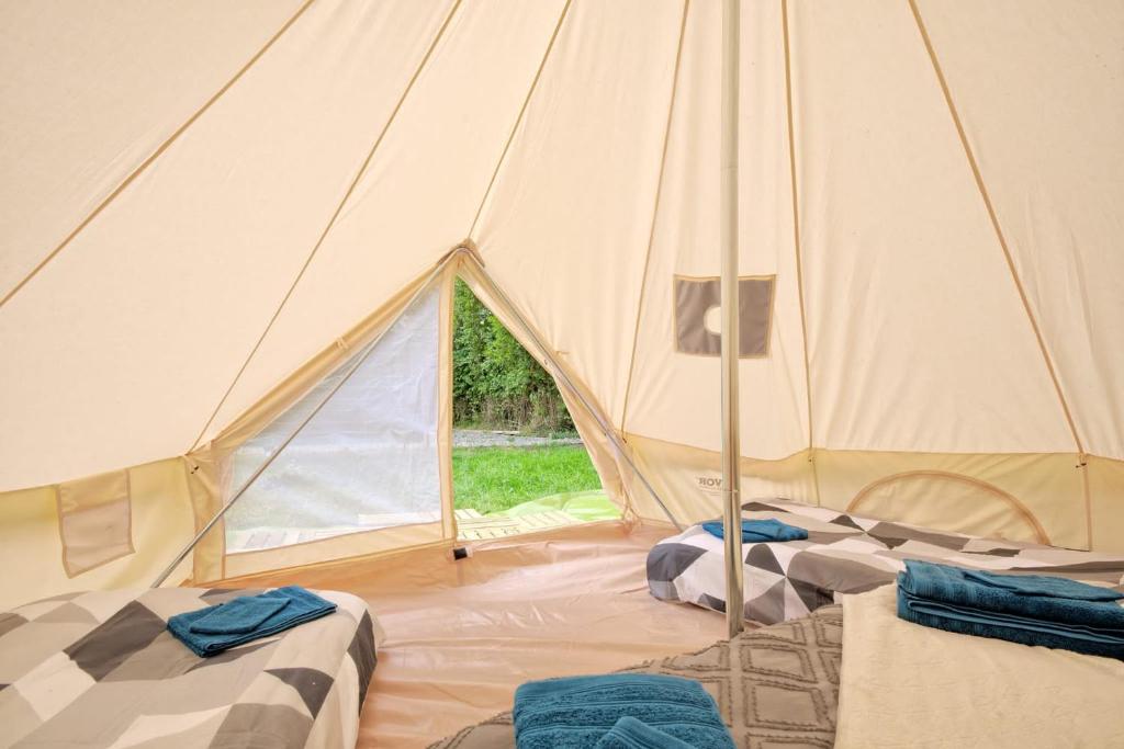 une tente avec 2 lits dans une chambre dans l'établissement Tipi Expérience L'échappée Belle, à Saint-Maudez