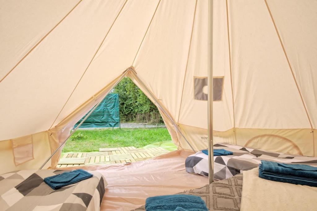 une tente avec 2 lits à l'intérieur dans l'établissement Tipi Expérience L'échappée Belle, à Saint-Maudez