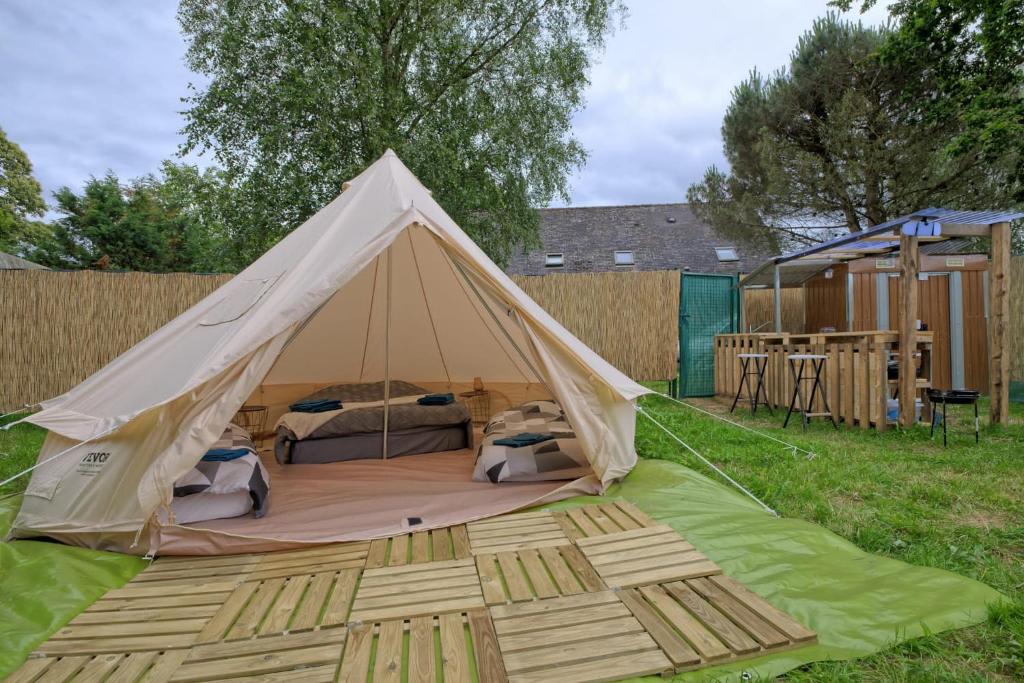une tente avec deux lits dans l'herbe dans l'établissement Tipi Expérience L'échappée Belle, à Saint-Maudez