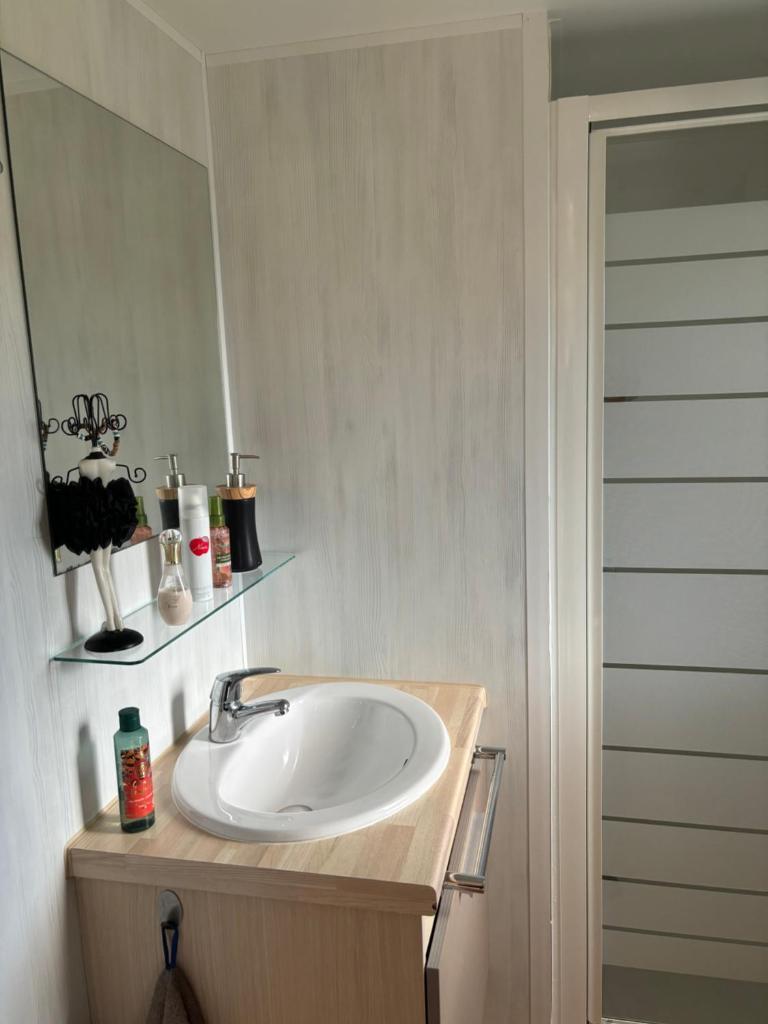 une salle de bain avec un lavabo et un miroir dans l'établissement Mobilhome cosy 520, à Saint-Arnoult