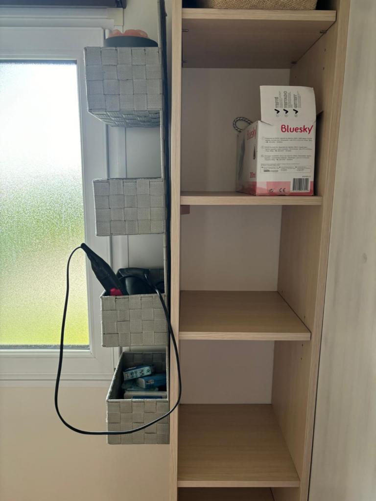 une armoire avec quelques étagères et un fil dans l'établissement Mobilhome cosy 520, à Saint-Arnoult