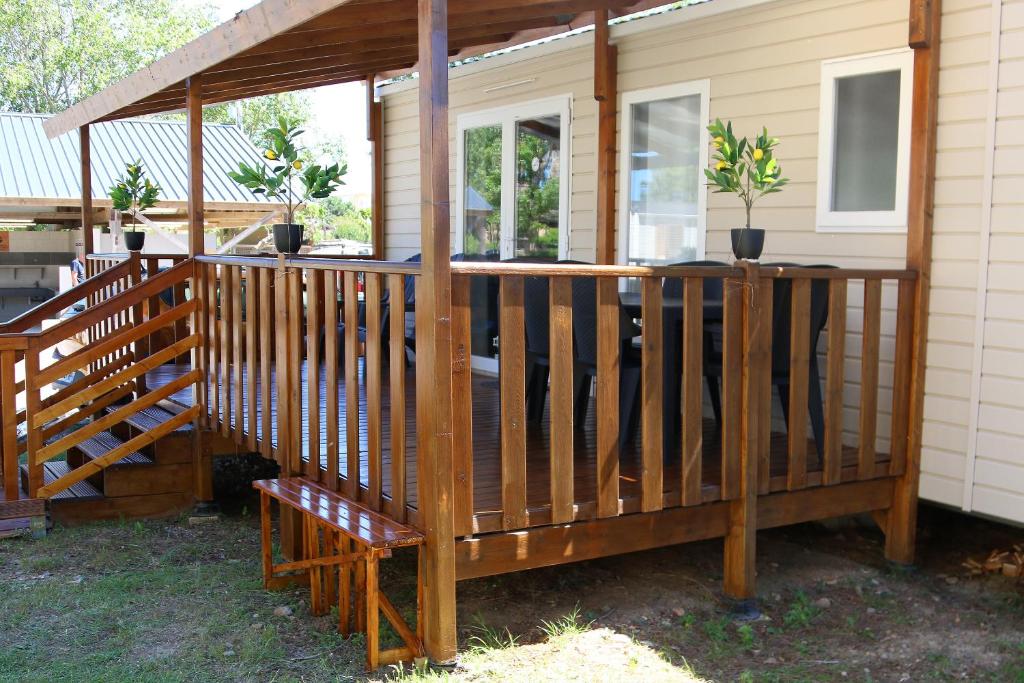 une terrasse en bois avec une balustrade en bois sur une maison dans l'établissement Mobil-home Narbonne-Plage, à Narbonne-Plage